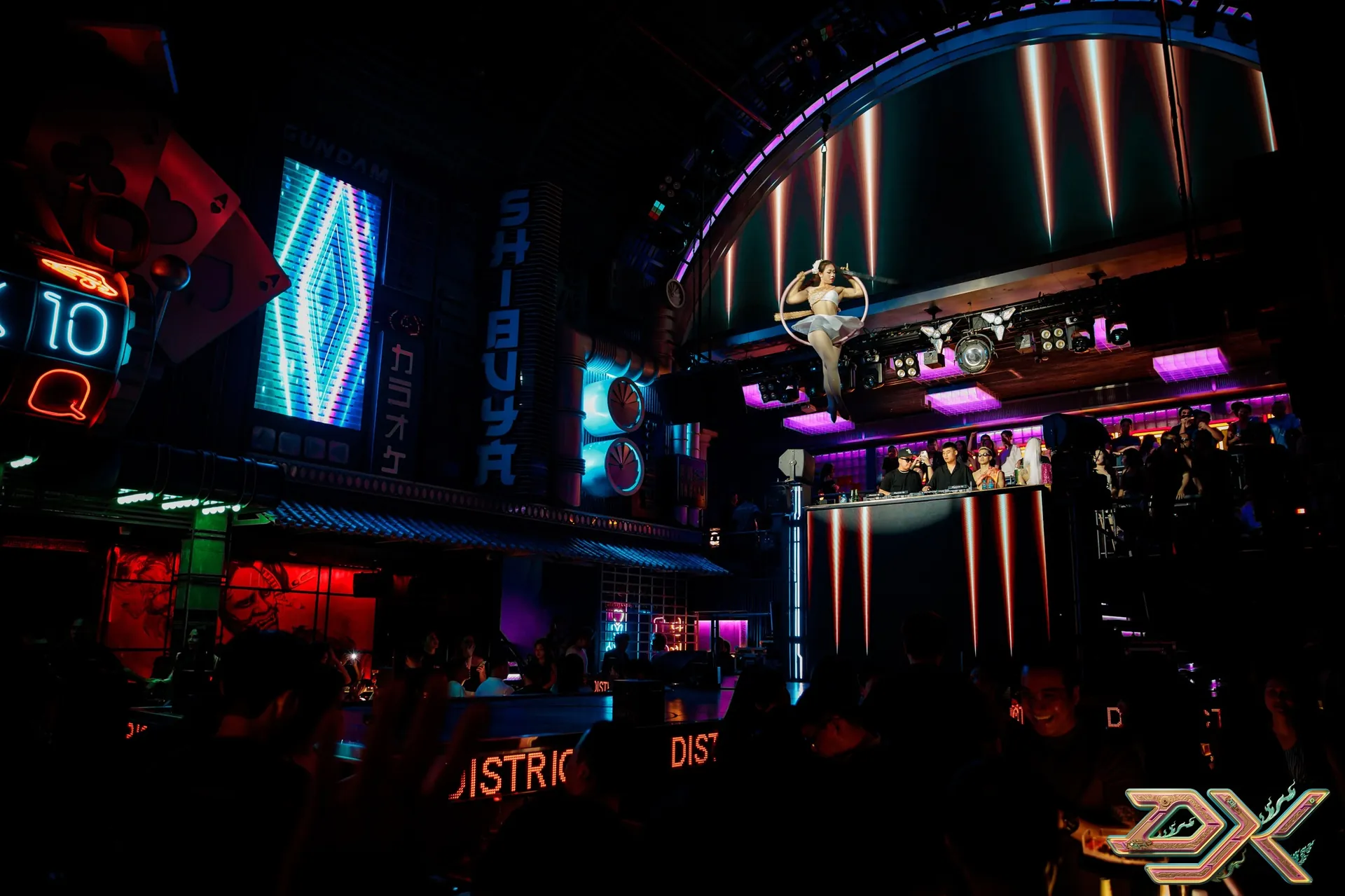 District K — quầy bar và signage neon đa tầng